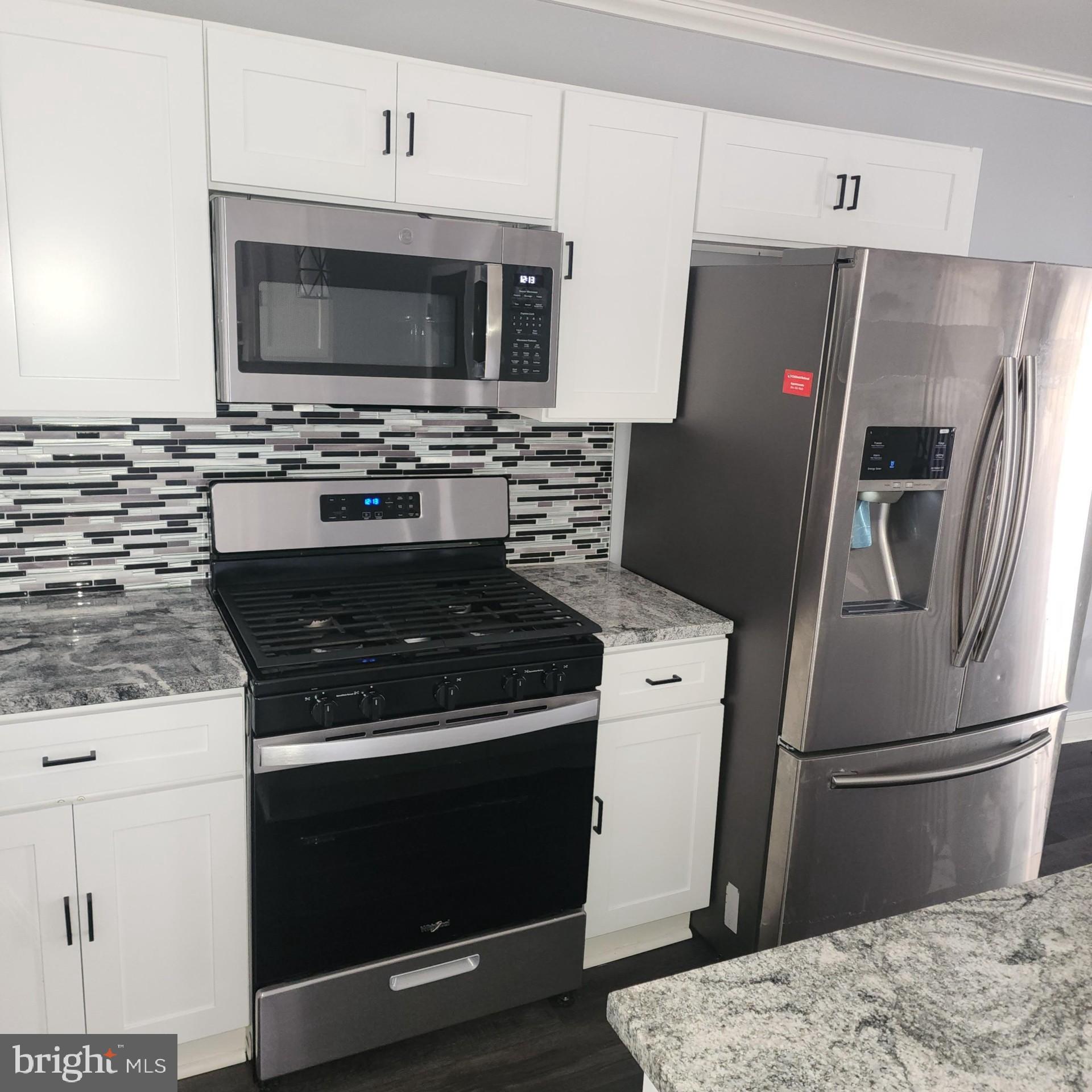 327 Grove Park Road Brooklyn, MD 21225 - Photo 6 of 20 a kitchen with a stove microwave and refrigerator