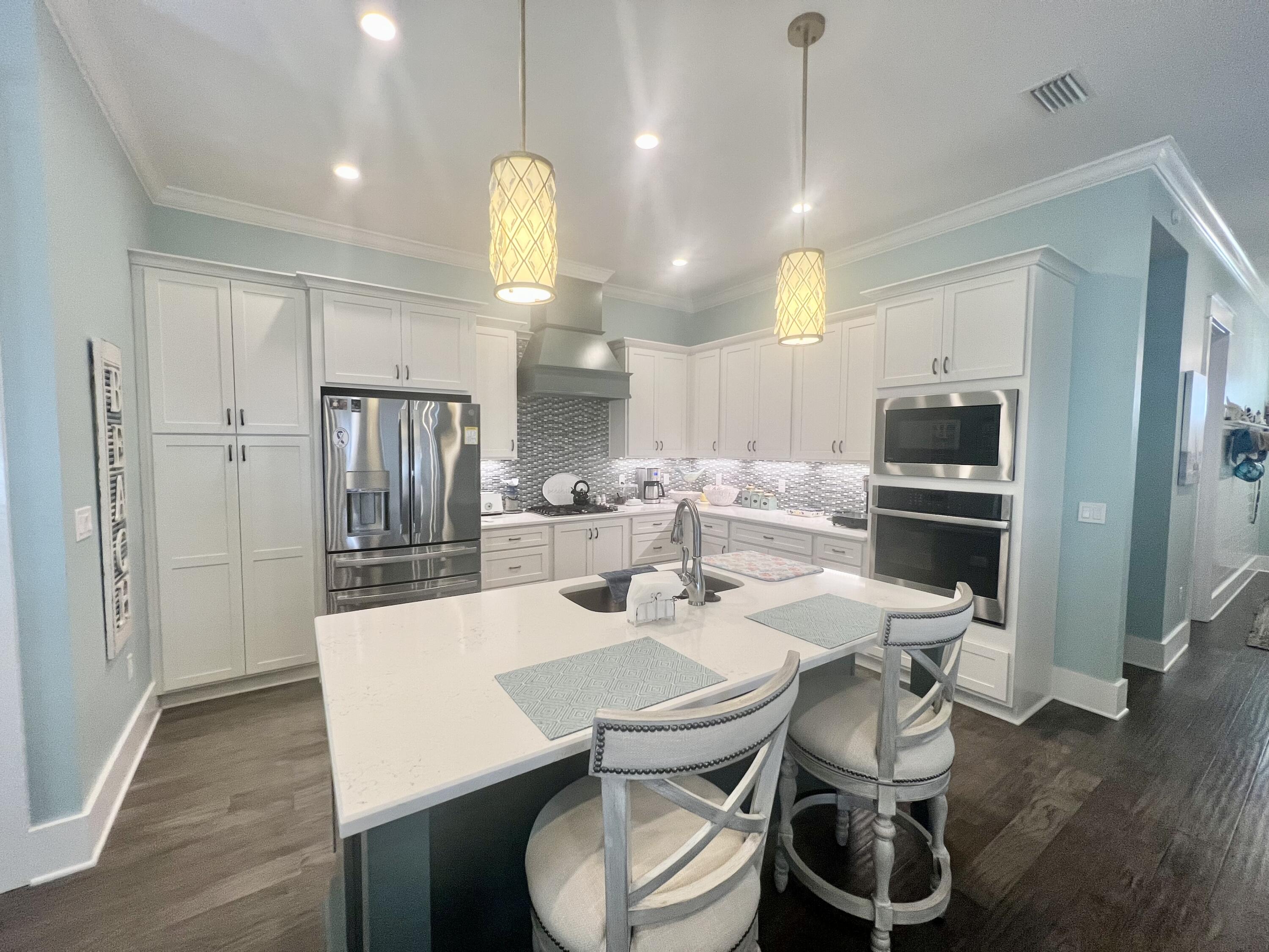 244 Perimeter Place Freeport, FL 32439 - Photo 33 of 72 a kitchen with stainless steel appliances a dining table chairs and wooden floor