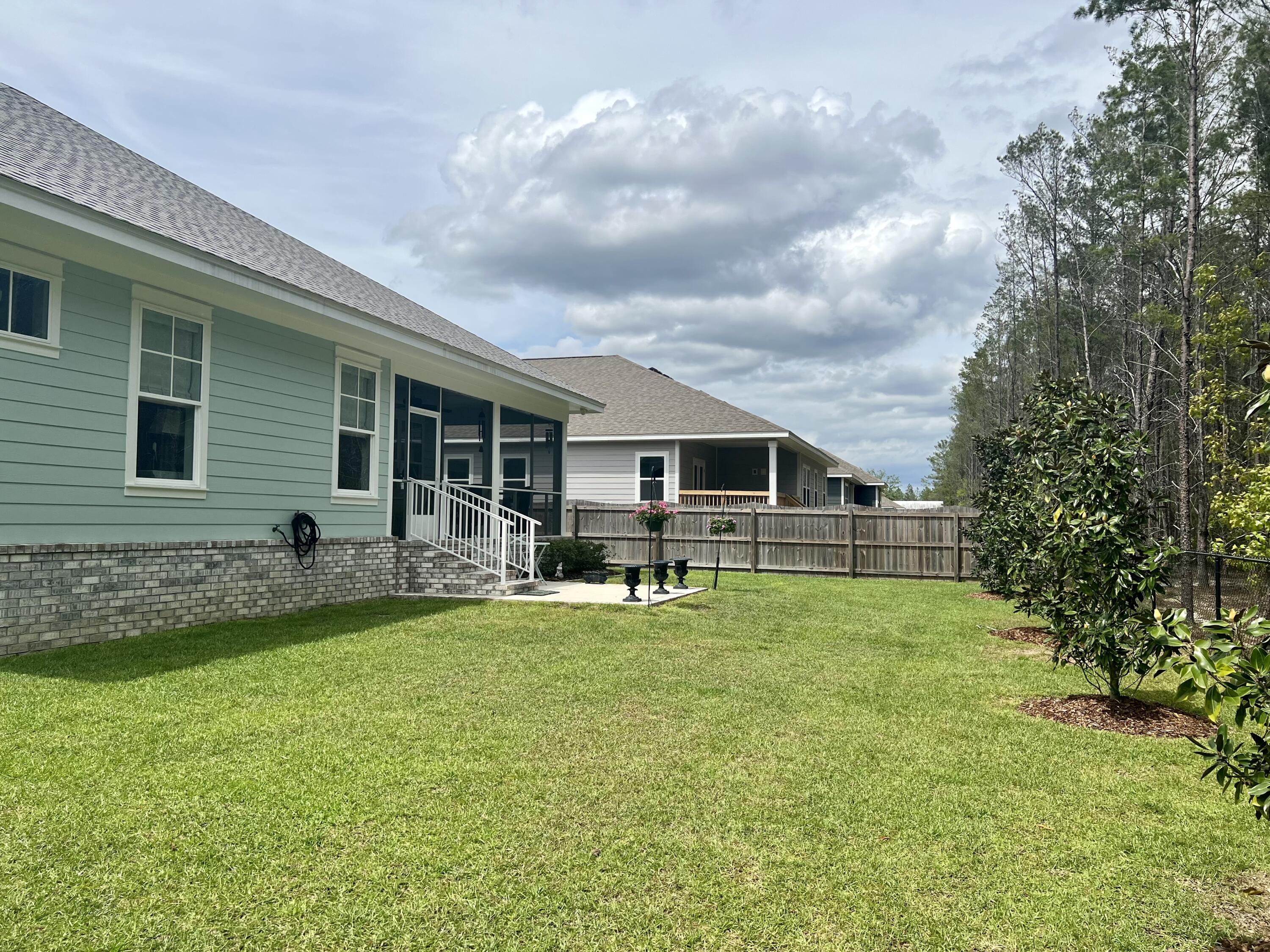 244 Perimeter Place Freeport, FL 32439 - Photo 70 of 72 a backyard of a house with table and chairs and potted plants