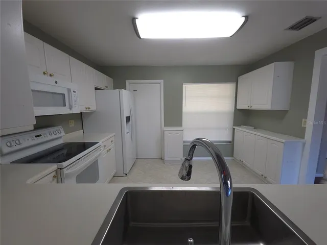 an empty room with wooden floor and windows in it