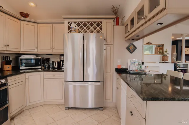 a kitchen with stainless steel appliances granite countertop a sink a stove and a granite counter tops with white cabinets