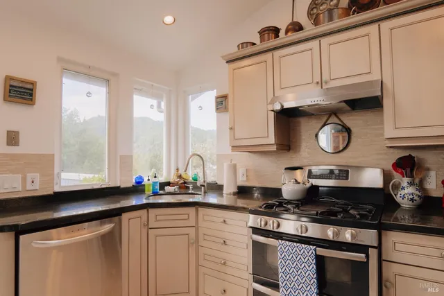 a kitchen with white cabinets and appliances