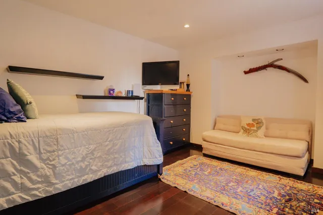 a bedroom with a bed and a flat screen tv