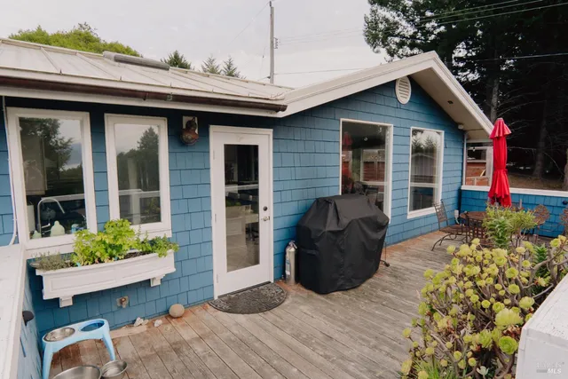 a view of a patio with table and chairs potted plants and large tree