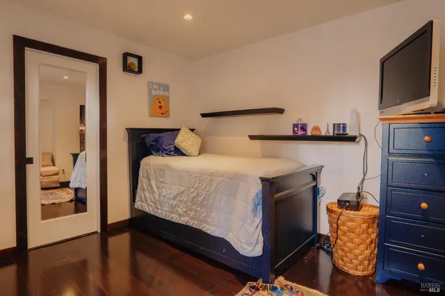 a bedroom with a bed and flat tv screen