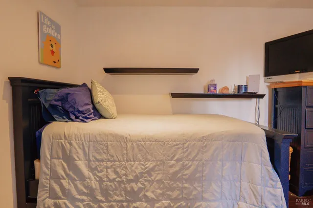 a bedroom with a bed and a flat screen tv