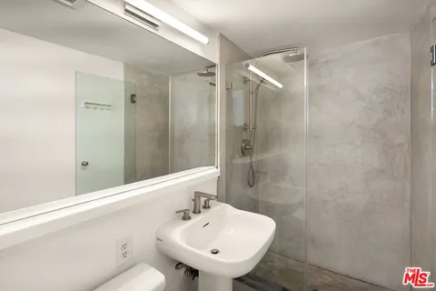 a bathroom with a sink mirror and shower