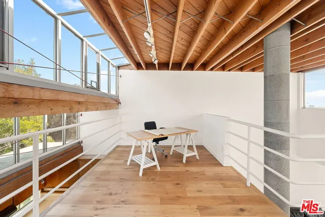 a dining room with wooden floor and white walls