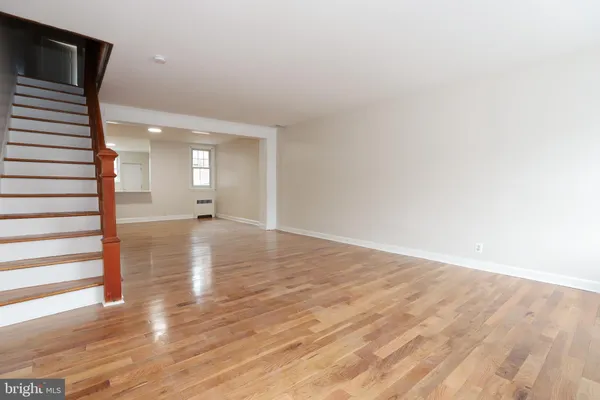 a view of a room with wooden floor and a window