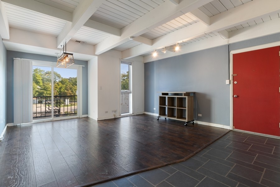 2114 Central Street, Unit A Evanston, IL 60201 - Photo 3 of 10 an empty room with wooden floor and windows