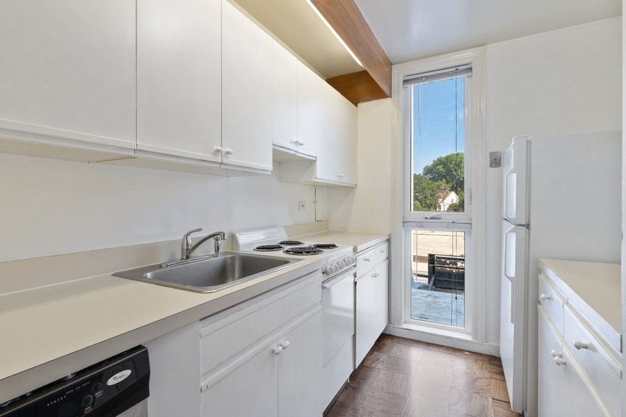 2114 Central Street, Unit A Evanston, IL 60201 - Photo 4 of 10 a kitchen with sink a stove and cabinets
