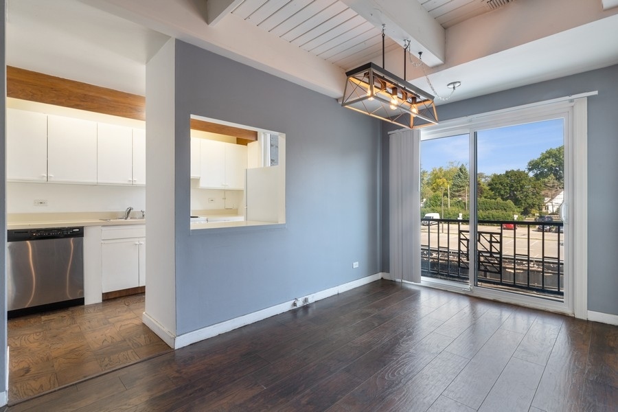 2114 Central Street, Unit A Evanston, IL 60201 - Photo 6 of 10 a view of a room with wooden floor a ceiling fan and windows