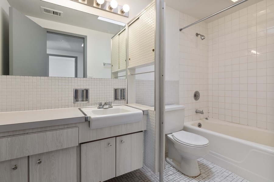 2114 Central Street, Unit A Evanston, IL 60201 - Photo 10 of 10 a bathroom with a sink toilet a shower and a mirror