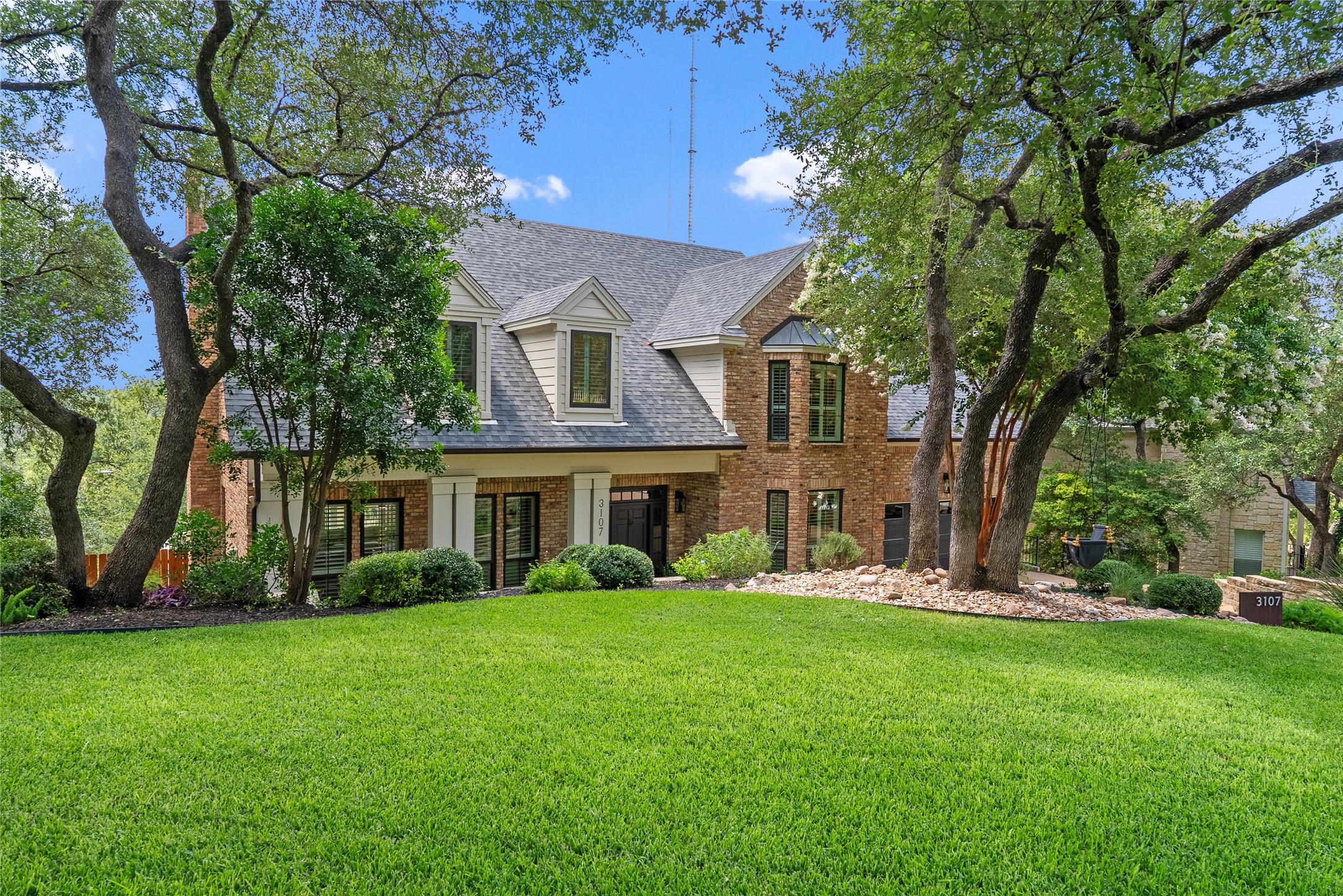 3107 Lookout Lane Austin, TX 78746 - Photo 2 of 39 A classic brick exterior with dormer windows and mature trees defines this grand residence.