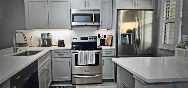 a kitchen with stainless steel appliances granite countertop a sink a stove and a refrigerator