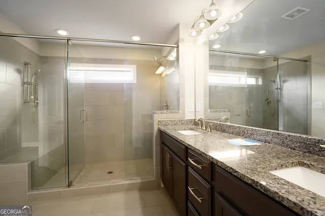 a bathroom with a granite countertop shower sink and mirror