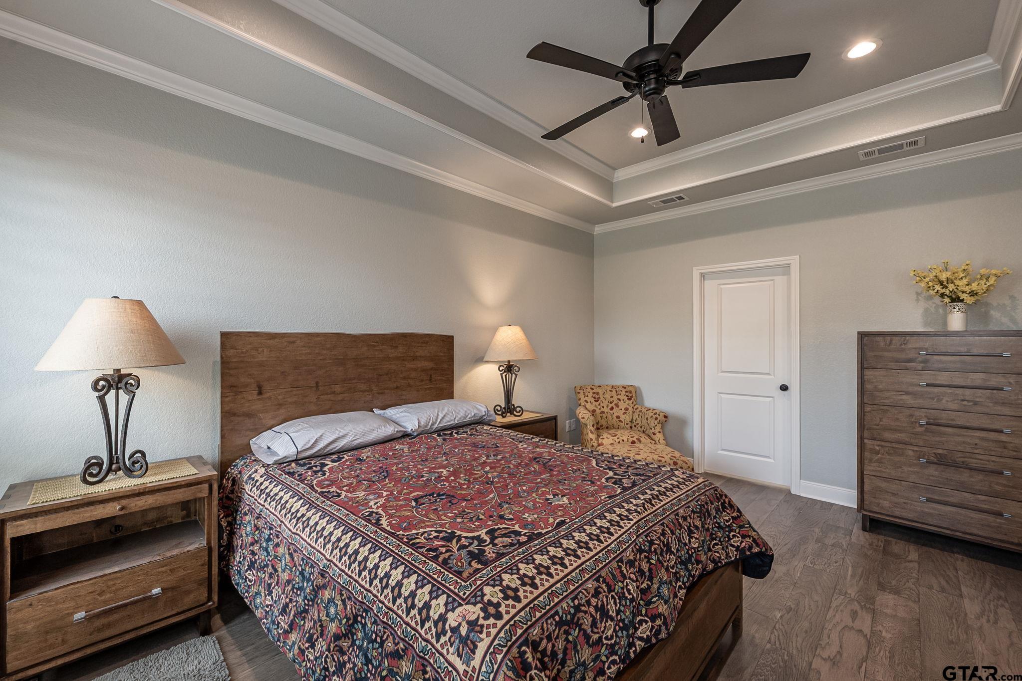 11858 Gillian Court Tyler, TX 75703 - Photo 10 of 24 a bedroom with a bed and a chandelier