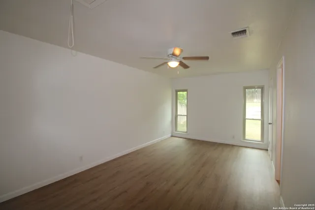 wooden floor in an empty room with a window