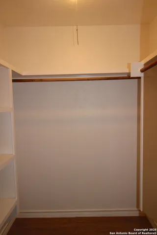 a view of a closet with wooden floor