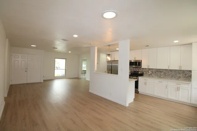 a view of kitchen with stainless steel appliances a refrigerator and a stove top oven