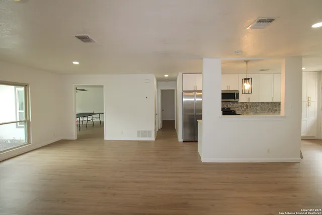 a view of a kitchen with refrigerator and windows