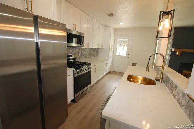 a kitchen with a refrigerator stove and sink