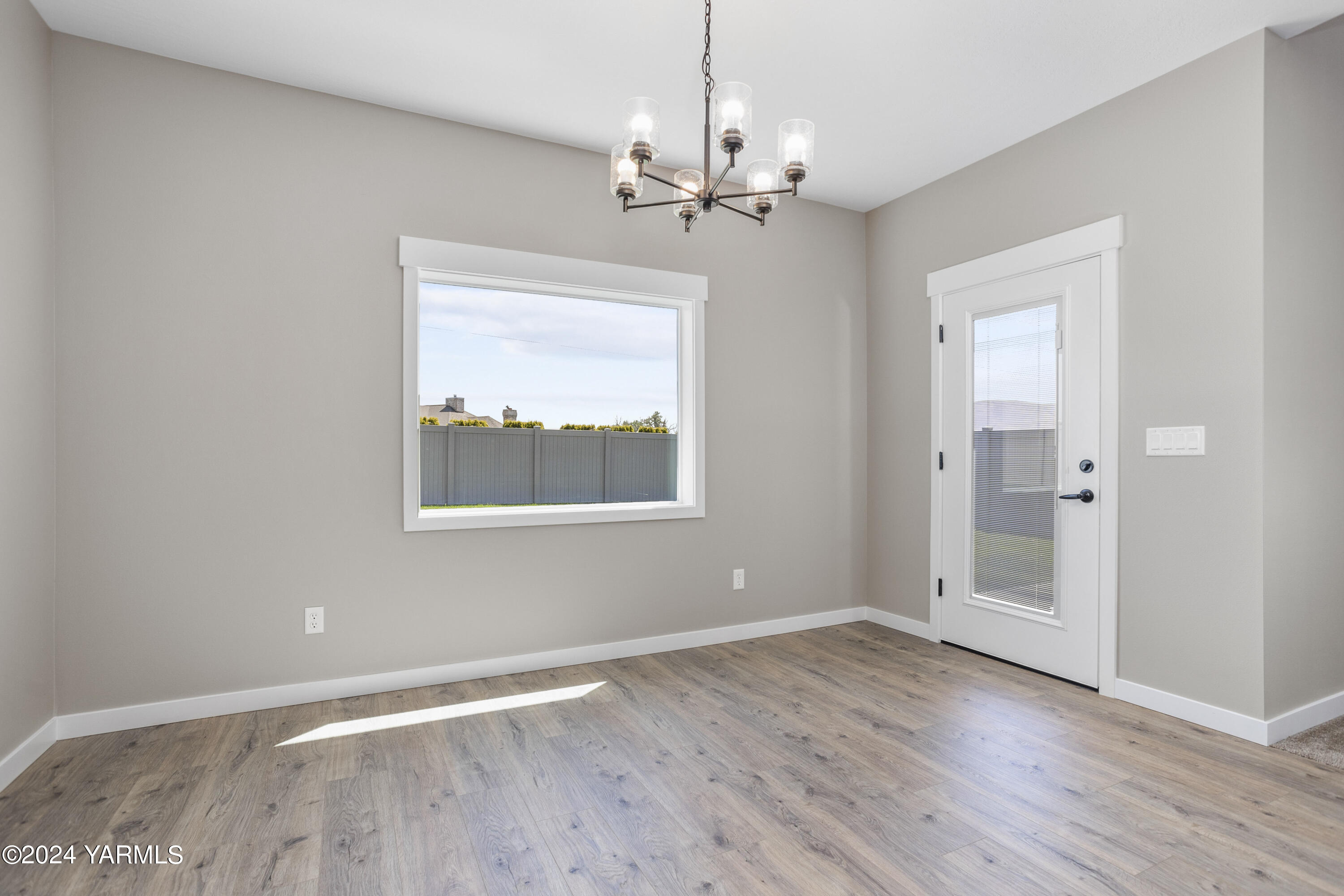 116 Scott Road Prosser, WA 99350 - Photo 6 of 38 an empty room with wooden floor chandelier and windows