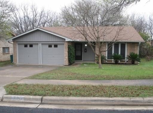 a view of a house with a yard and large tree