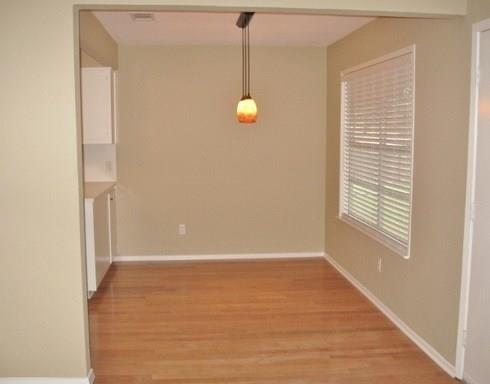 9807 Mountain Quail Road Austin, TX 78758 - Photo 5 of 19 a view of an empty room with wooden floor and a window