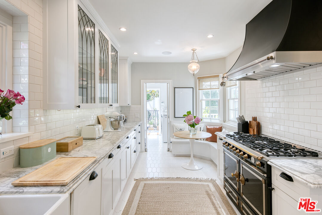 10736 Le Conte Avenue Los Angeles, CA 90024 - Photo 11 of 44 a large white kitchen with stainless steel appliances a stove a sink a chimney and a refrigerator