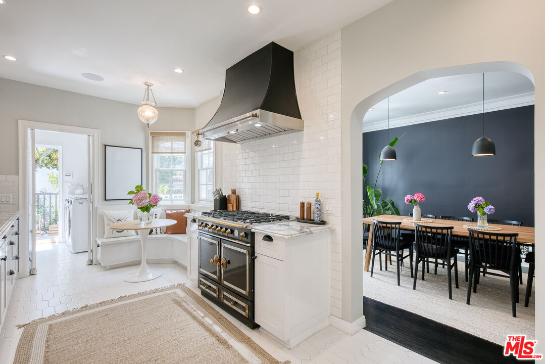 10736 Le Conte Avenue Los Angeles, CA 90024 - Photo 12 of 44 a kitchen with stainless steel appliances a stove a table chairs and white cabinets