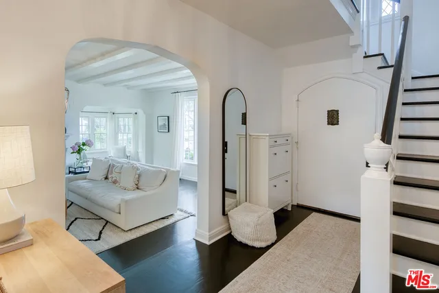 a kitchen with stainless steel appliances a stove a table chairs and white cabinets