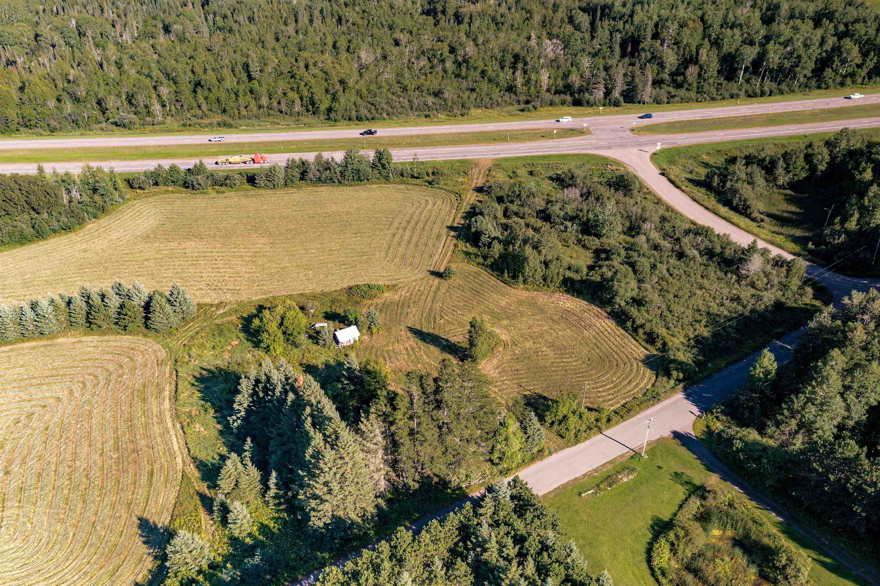 Aerial view of property's location featuring rural landscape and a heavily wooded area