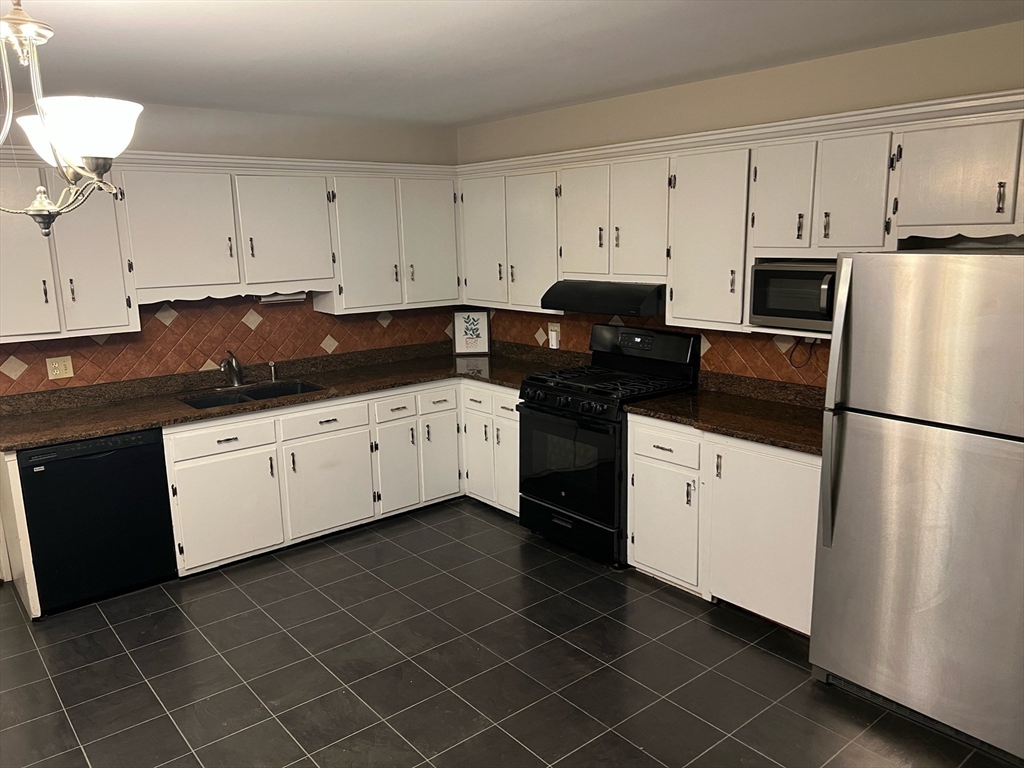 76 Allston Street Lawrence, MA 01841 - Photo 3 of 6 a kitchen with granite countertop a white cabinets and white appliances