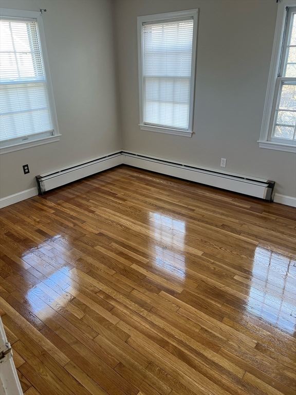 76 Allston Street Lawrence, MA 01841 - Photo 4 of 6 an empty room with wooden floor and windows