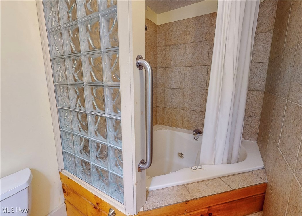5696 Steubenville Road Southeast Amsterdam, OH 43903 - Photo 32 of 50 Bathroom with toilet and shower / bathtub combination with curtain