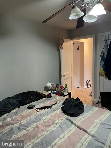 a bed room with a bed a couch and a chandelier