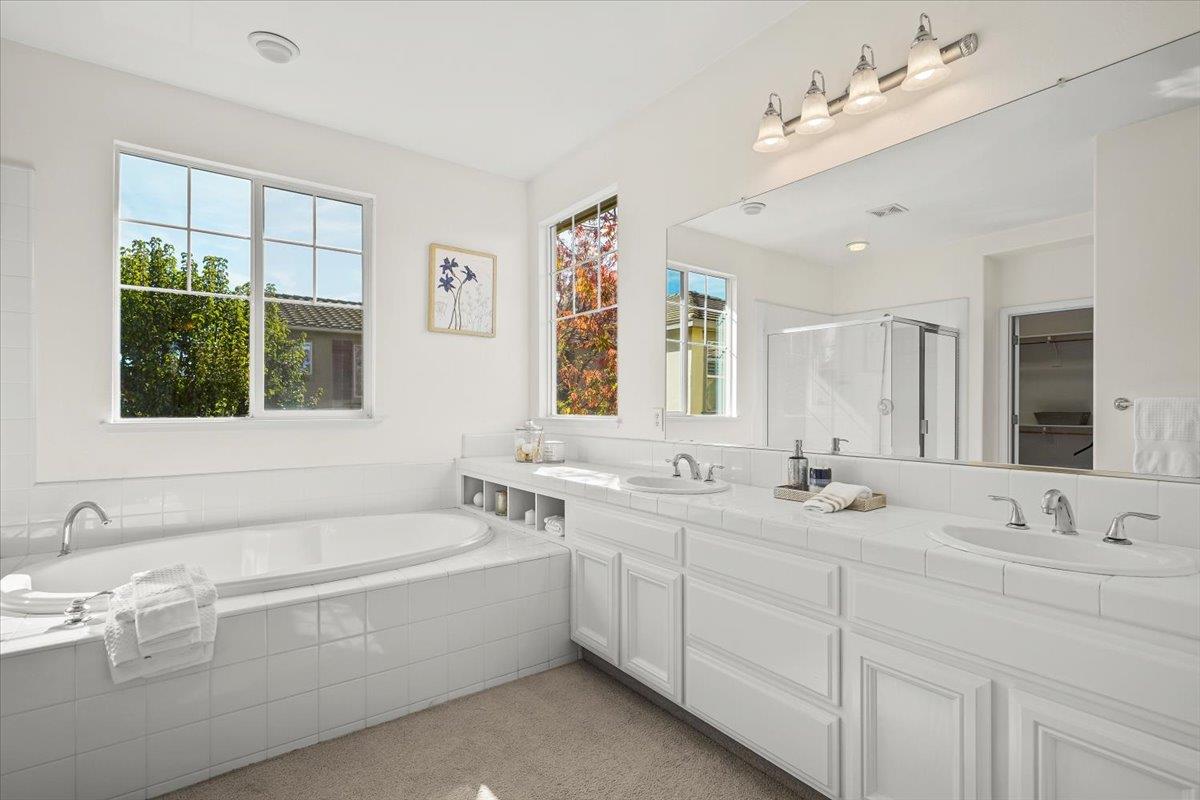 2144 Gullane Way Gilroy, CA 95020 - Photo 11 of 22 a bathroom with double vanity sinks a large mirror and a bathtub