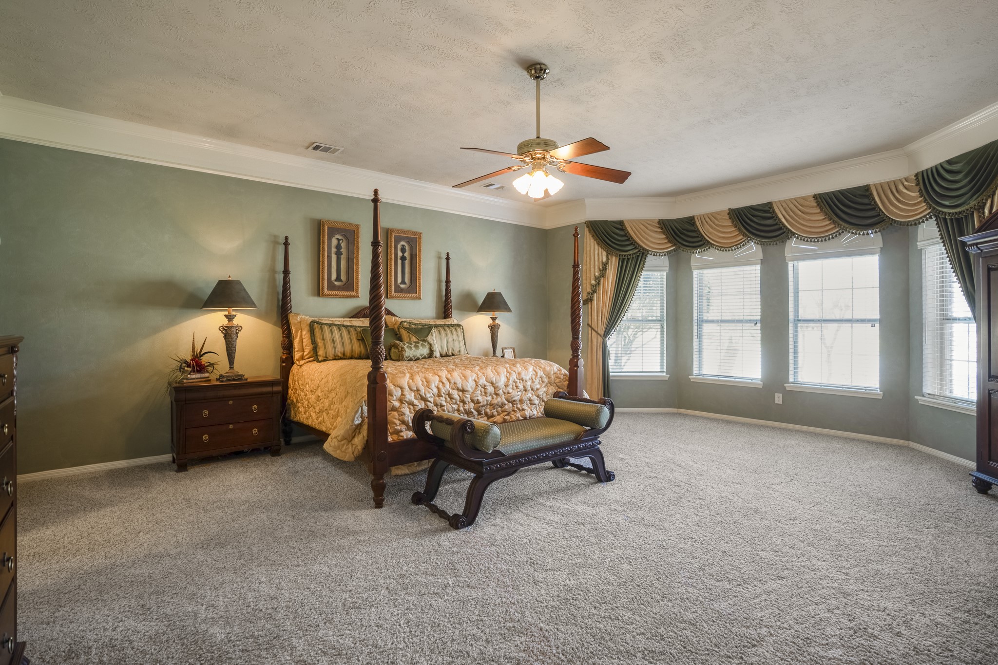 6615 Haughton Drive Spring, TX 77389 - Photo 18 of 50 Tucked on the main level, the primary suite makes an immediate impression with its generous size and elegant details. A wide bay window stretches across the back wall, filling the room with natural light and adding architectural dimension. Crown moulding traces the ceiling line, giving the space a finished, refined feel.
It’s a spacious retreat — open, airy, and designed to feel both grand and comfortable at the same time.