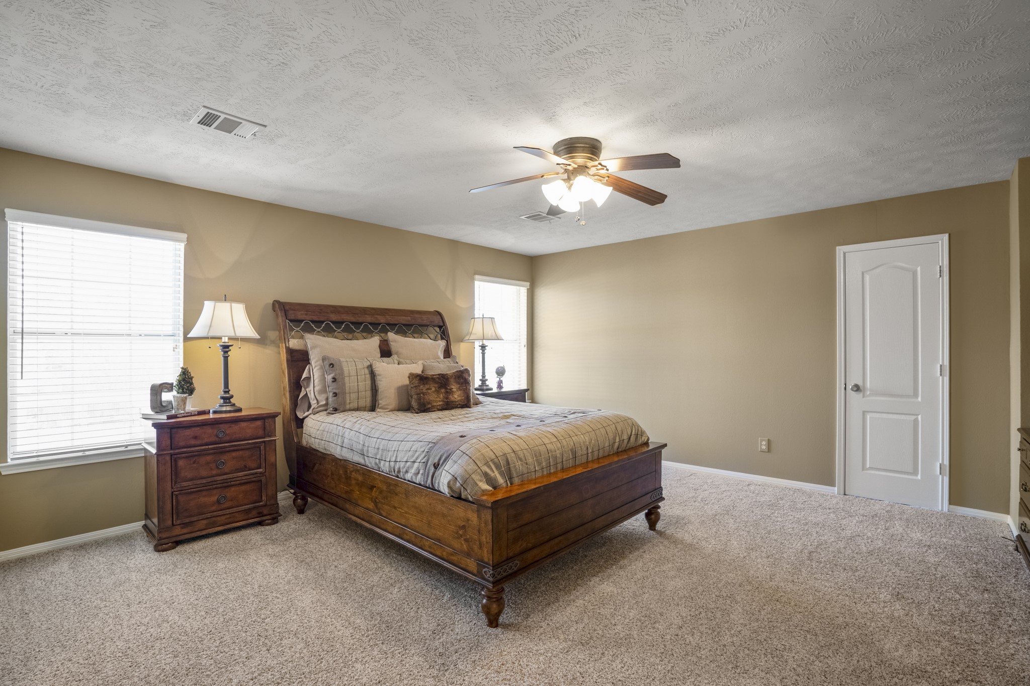 6615 Haughton Drive Spring, TX 77389 - Photo 31 of 50 The second of three upstairs bedrooms features two large windows that bring in abundant natural light, brightening the space throughout the day. A ceiling fan adds comfort overhead, while the neutral palette keeps the room feeling fresh and easy.