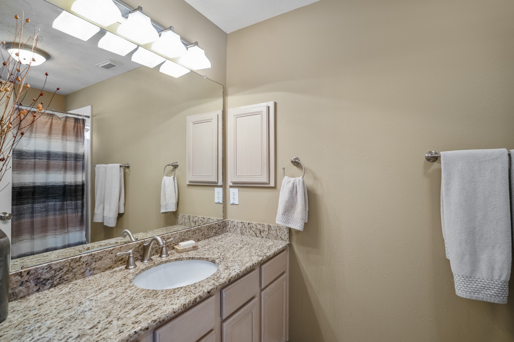 6615 Haughton Drive Spring, TX 77389 - Photo 33 of 50 Inside the adjoining bathroom, a long stretch of counter offers plenty of room to spread out, with a large mirror above reflecting both light and the shower/tub area behind.