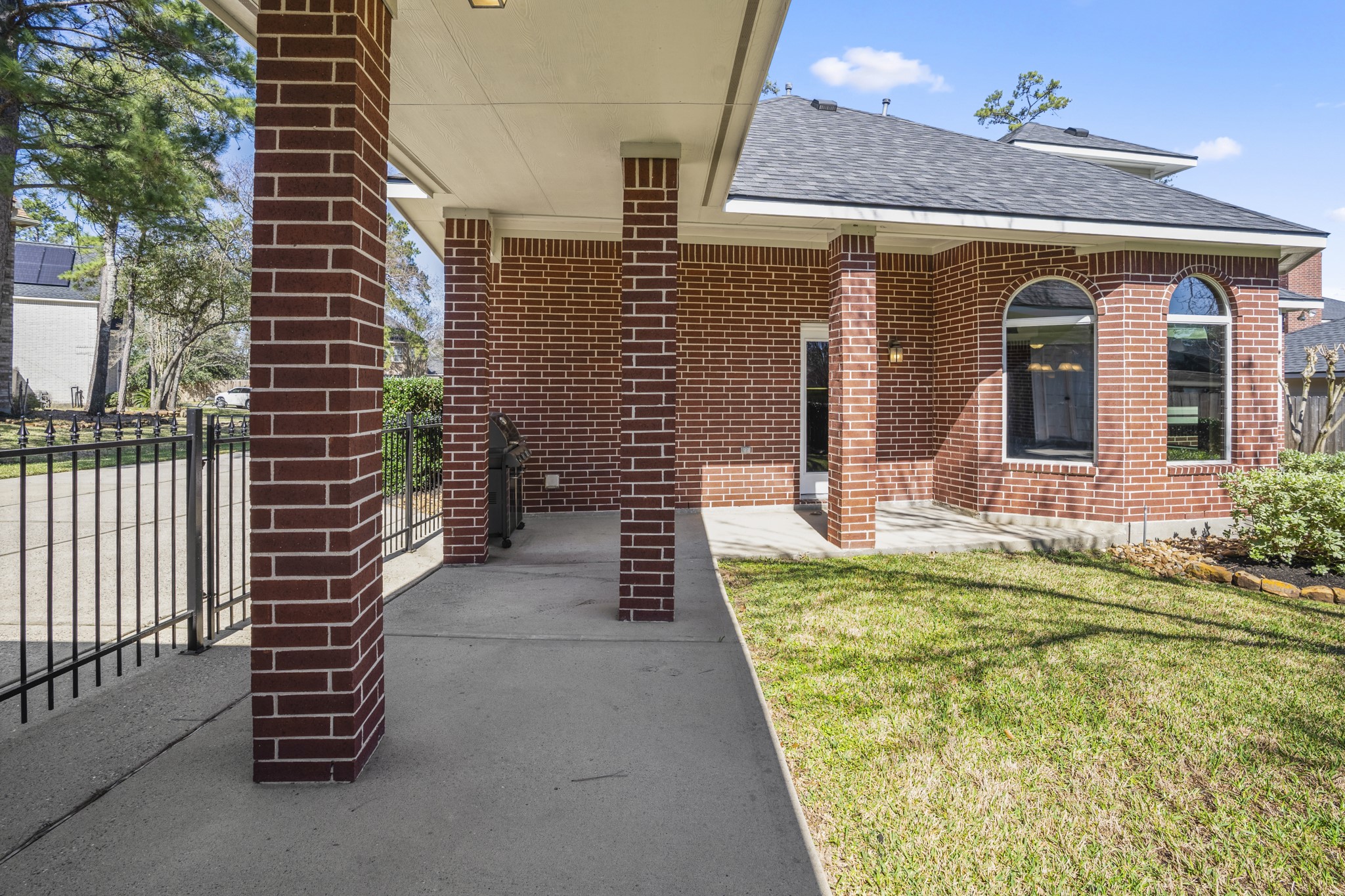 6615 Haughton Drive Spring, TX 77389 - Photo 37 of 50 Stepping back a bit farther, you can see how the covered patio transitions into the breezeway that connects the home to the detached three-car garage. The covered walkway keeps you sheltered as you move between spaces, while the gate just beyond opens to the extended driveway. It’s a thoughtful setup that adds convenience and flexibility to the backyard layout.