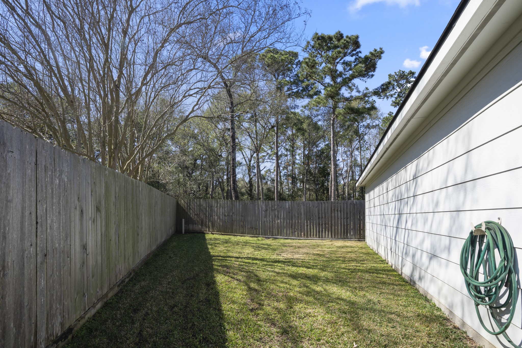 6615 Haughton Drive Spring, TX 77389 - Photo 42 of 50 Just behind the garage, a side yard area offers additional outdoor space tucked along the fence line. It’s a quiet extension of the backyard — ideal for storage, gardening, or simply keeping things neatly out of sight while preserving the main lawn for everyday use.