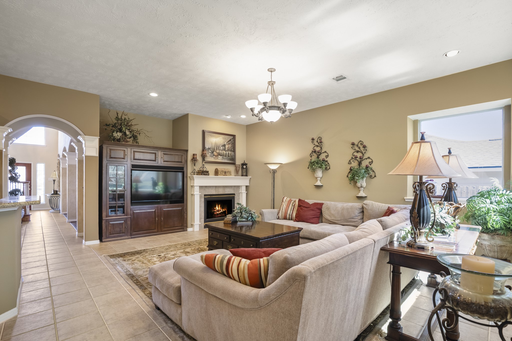 6615 Haughton Drive Spring, TX 77389 - Photo 9 of 50 From this angle, the living room settles in. The fireplace draws your eye first, while the recessed niche along the wall gives the TV and media setup a natural home without dominating the space. It’s easy to imagine evenings here — conversation around the fireplace, a show playing in the background, the room comfortably filled without feeling busy.