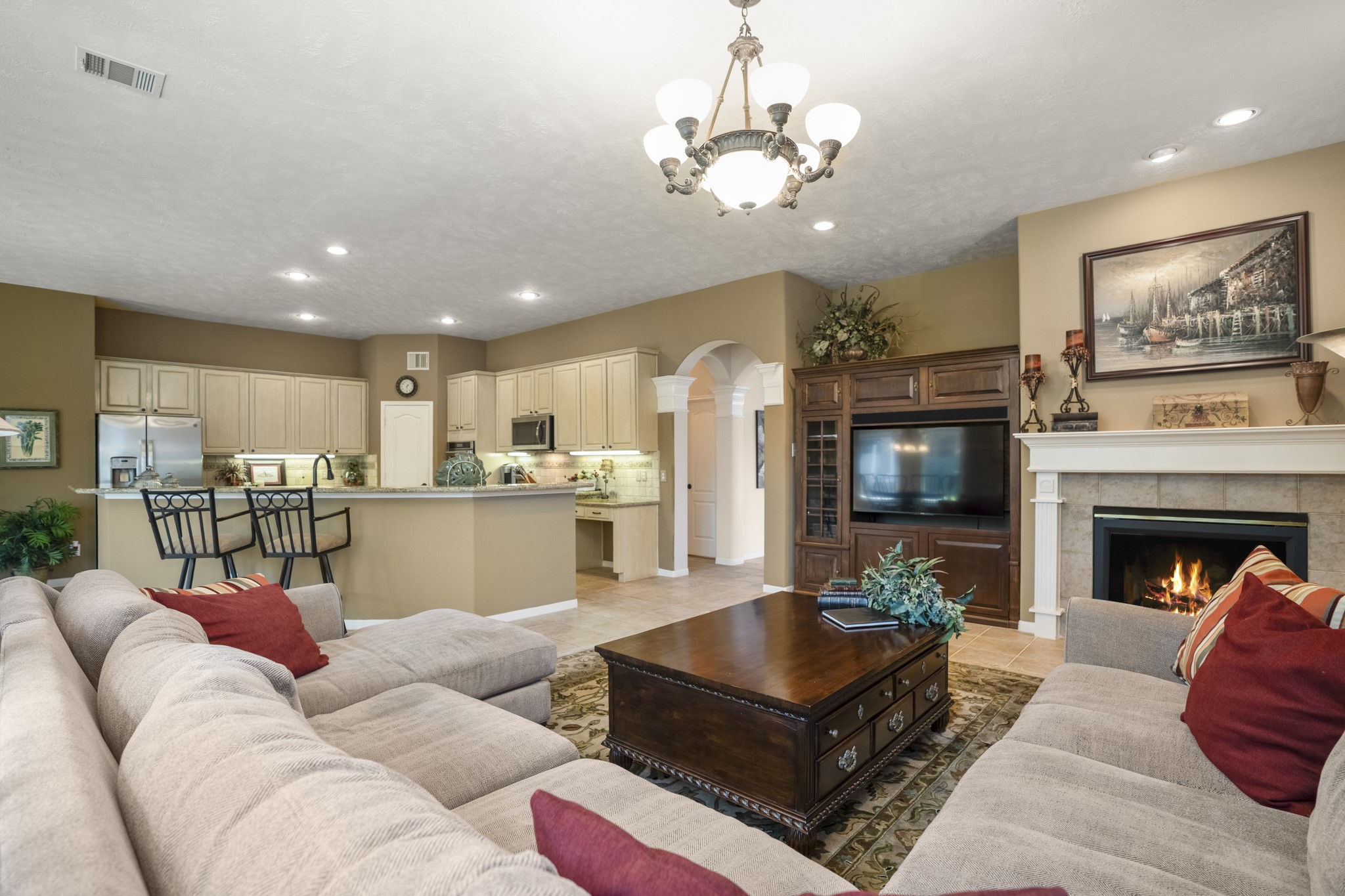 6615 Haughton Drive Spring, TX 77389 - Photo 10 of 50 From the opposite corner of the living room, the kitchen comes fully into view for the first time. Cabinetry lines the back wall, and the island anchors the space with room for bar seating and everyday prep. Everything feels within reach, making it easy to cook, gather, and stay connected to the activity nearby.
