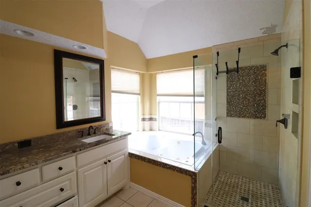 a bathroom with a granite countertop sink mirror and a bathtub