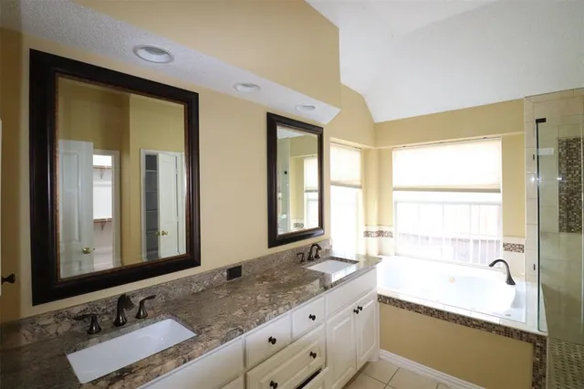 a bathroom with a granite countertop sink and a large mirror