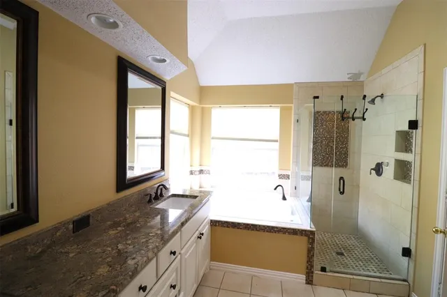 a bathroom with a granite countertop sink mirror bathtub and shower