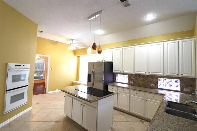 a kitchen with stainless steel appliances granite countertop a stove a sink and a refrigerator