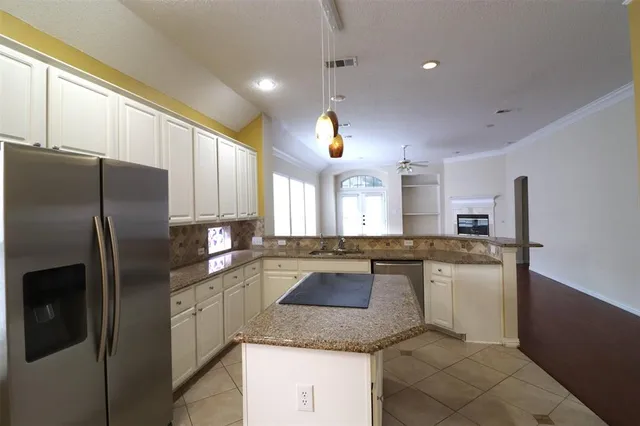 a kitchen with stainless steel appliances granite countertop a refrigerator a sink a stove and island